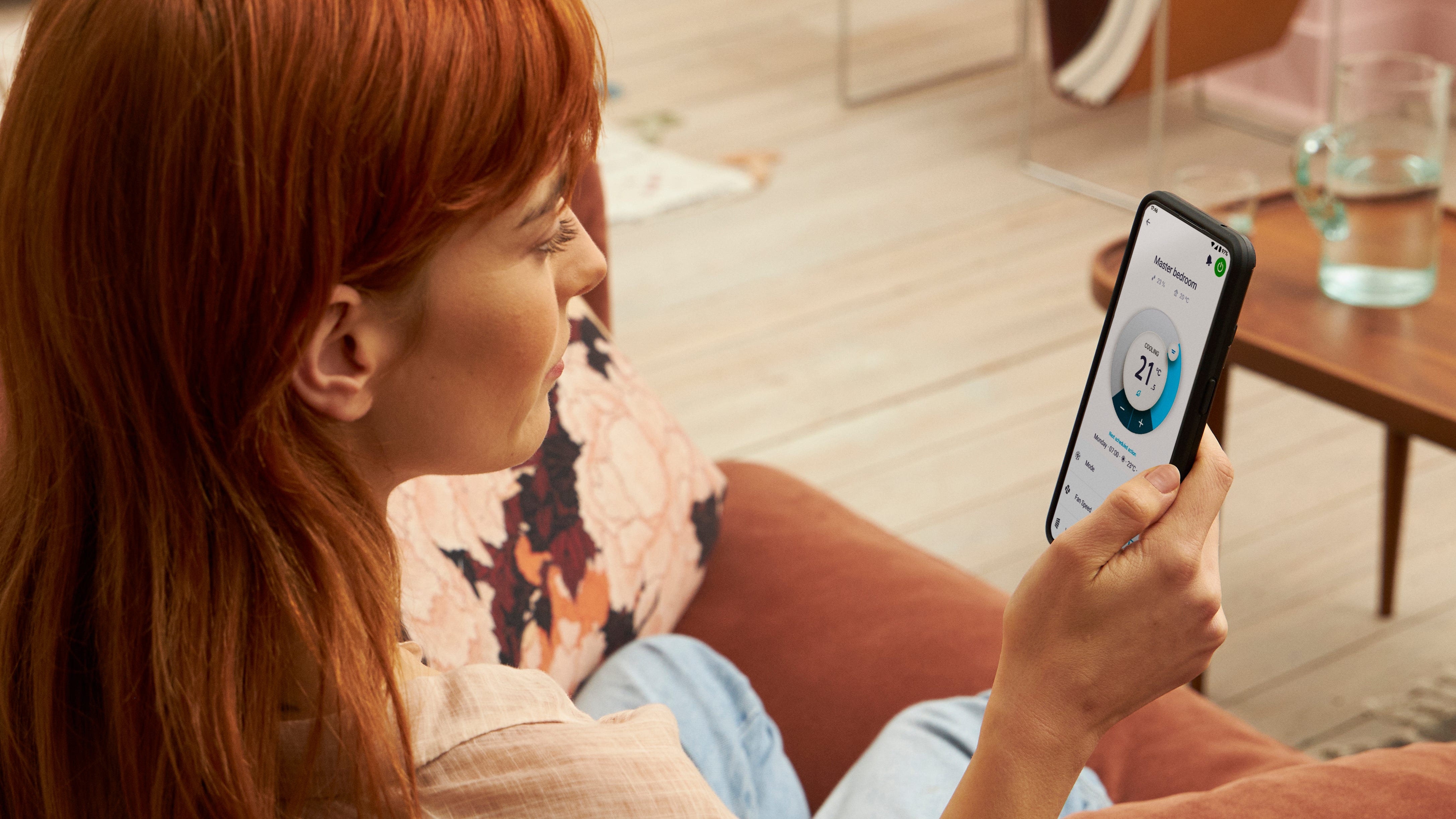 En kvinde bruger en app til at betjene sin opvarmningsløsning.