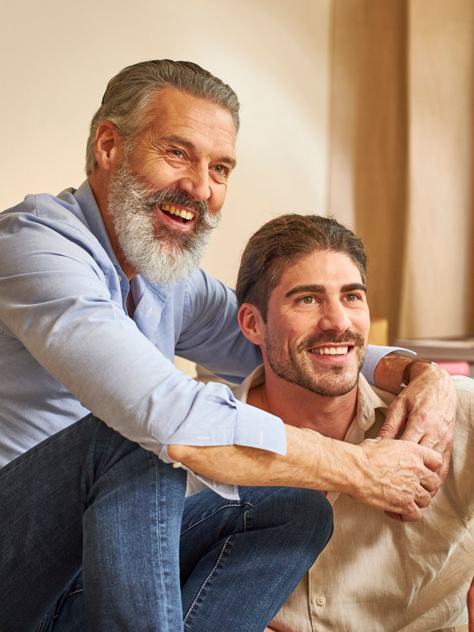 Far og voksen søn, der nyder et godt indeklima takket være en luftrenser fra Daikin.