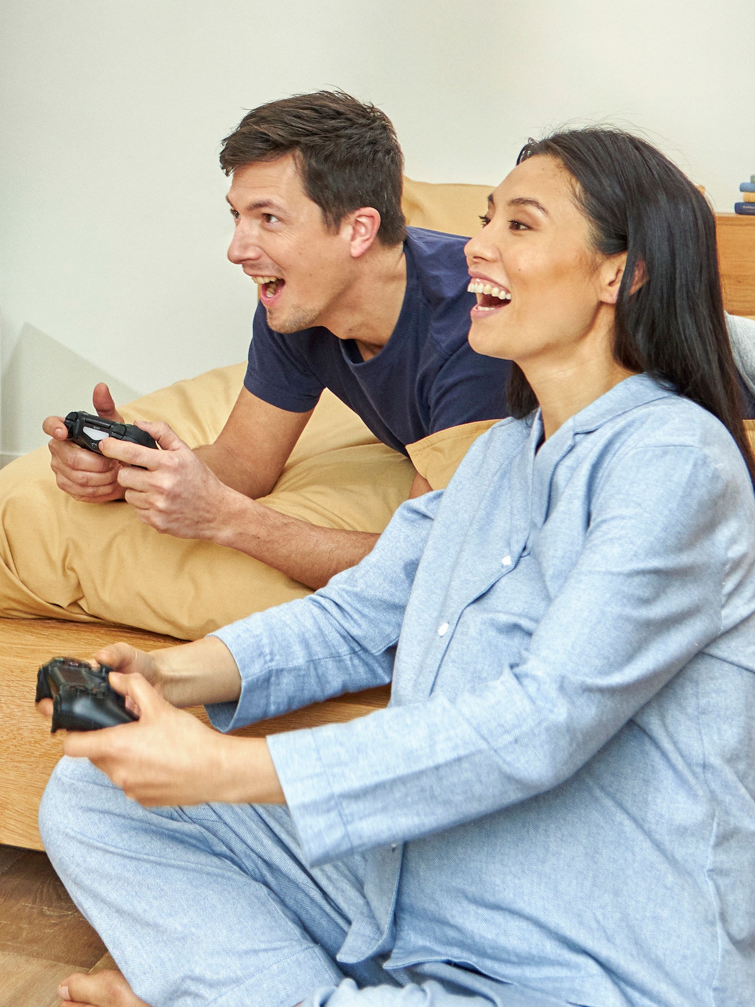 Vordende forældre hygger sig med at spille konsolspil i deres soveværelse.