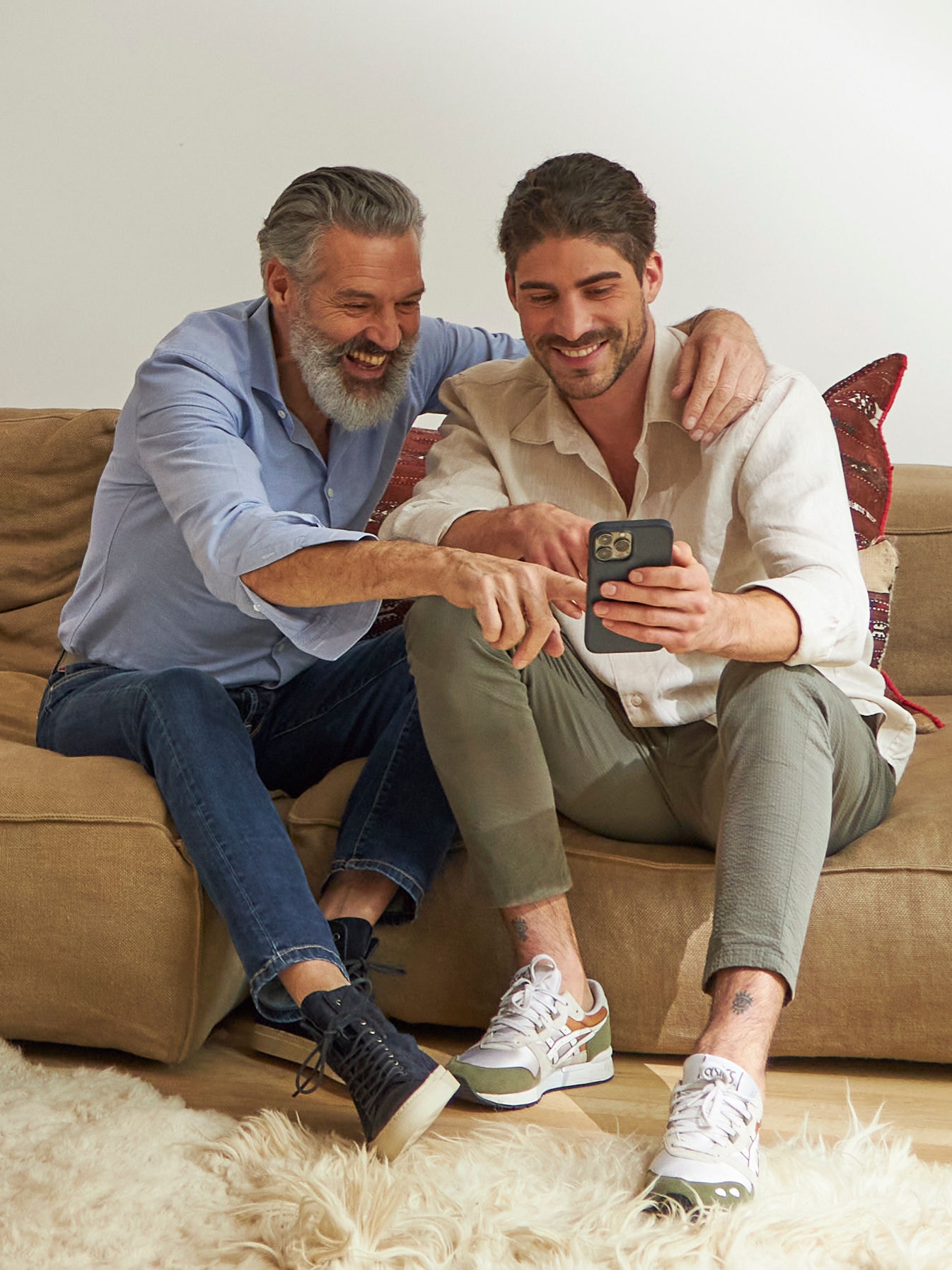 Far og søn slapper af i sofaen i en perfekt indendørstemperatur.