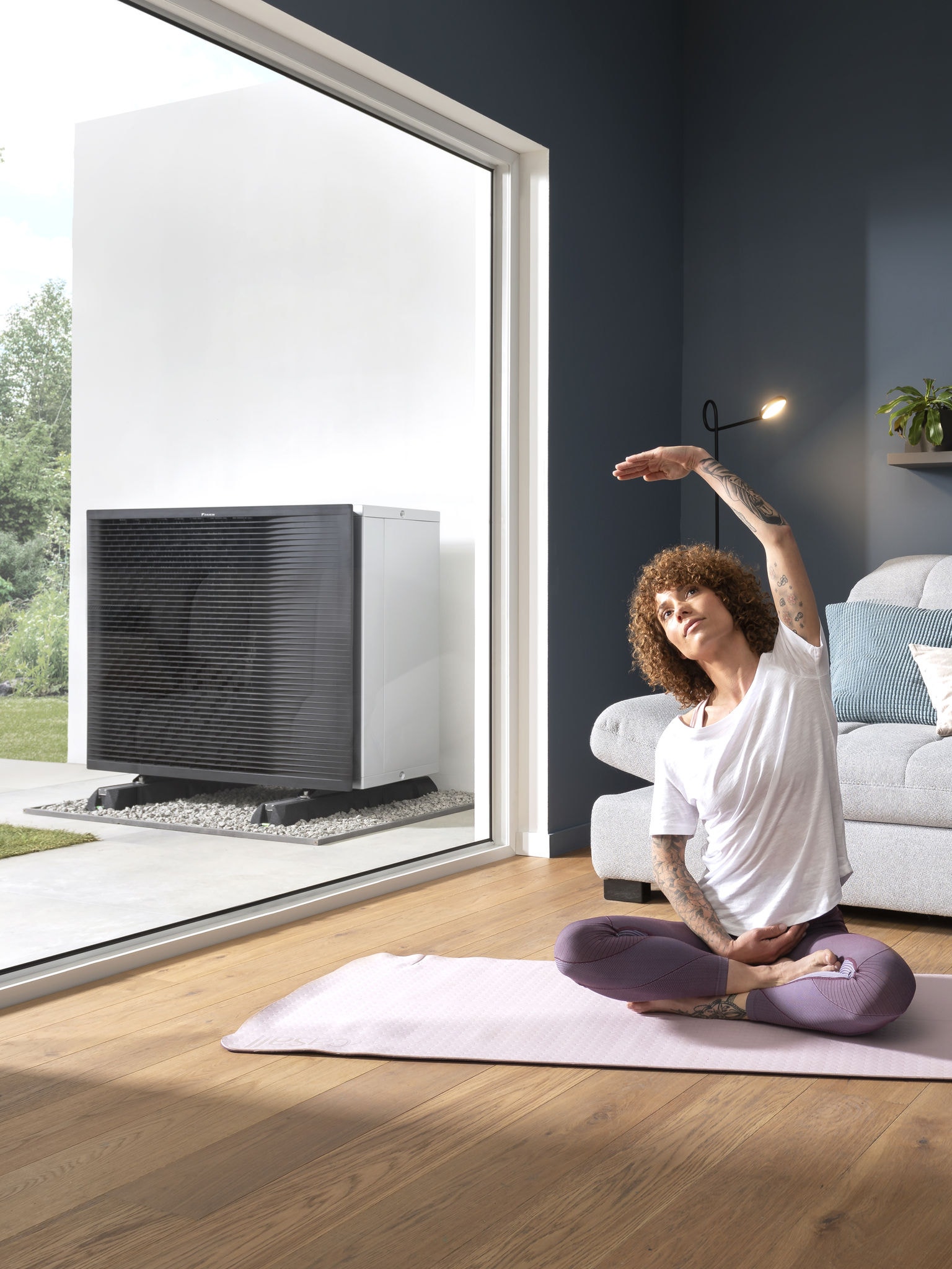 En kvinde dyrker yoga i sin stue.