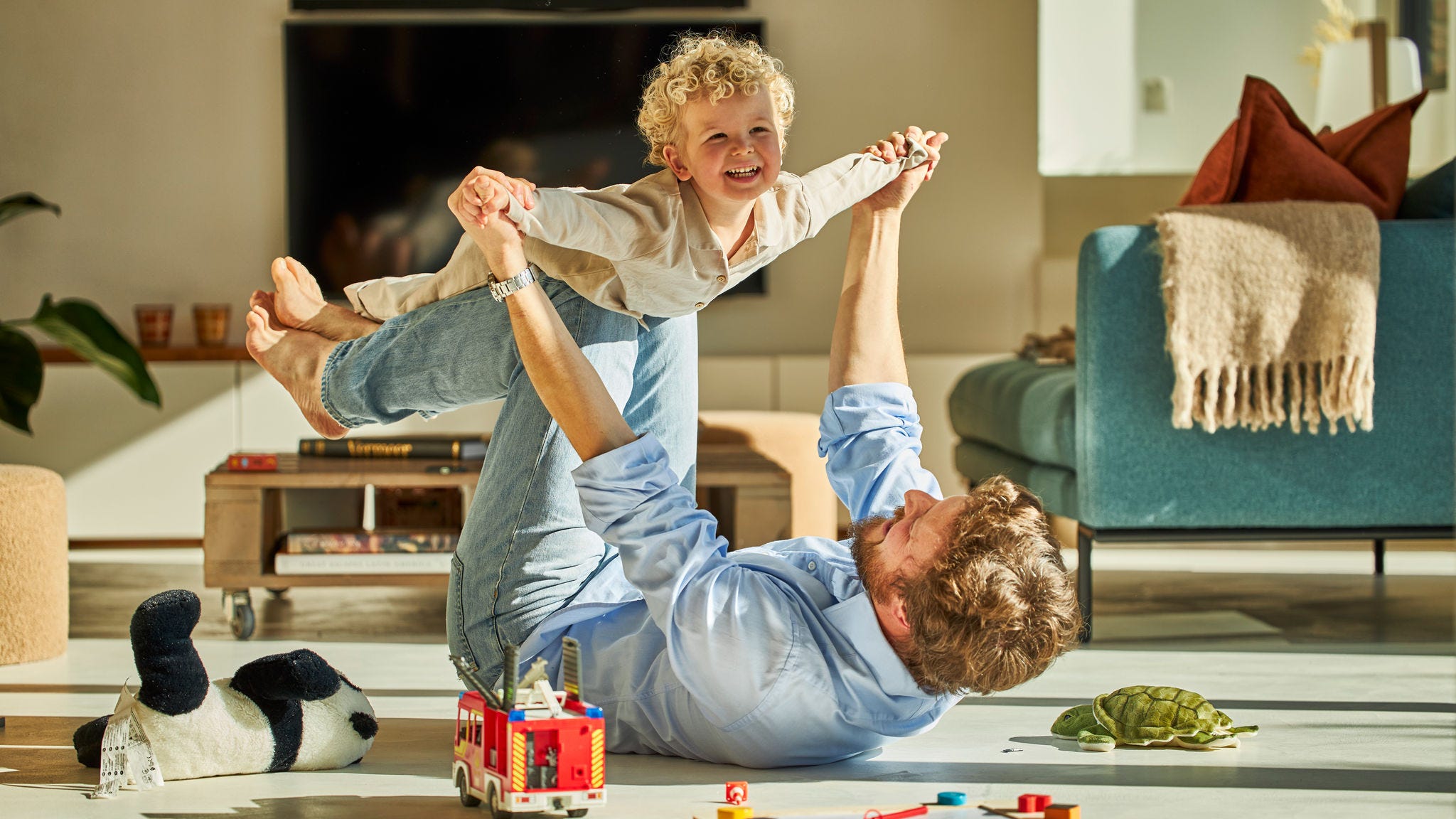Far og barn leger og har det sjovt sammen, mens de nyder gulvvarmen.